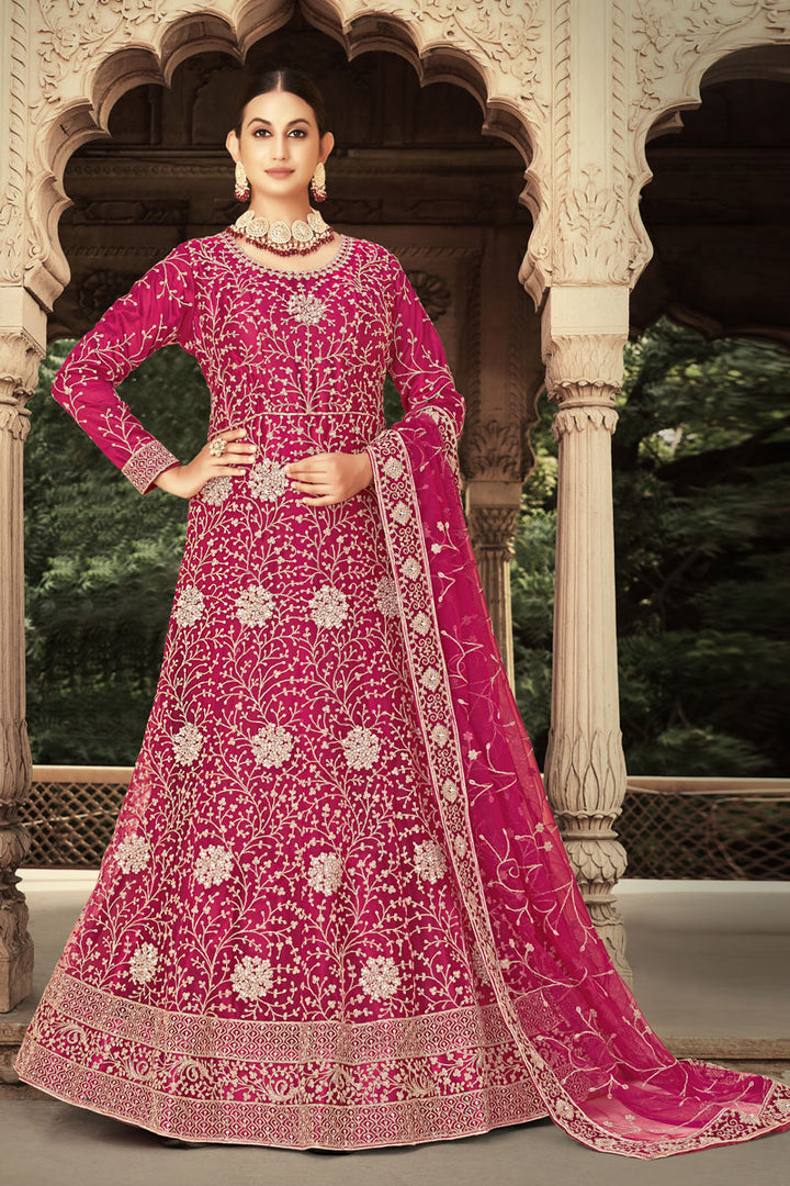 Fascinating Embroidered Work On Net Fabric Anarkali Suit In Rani Color