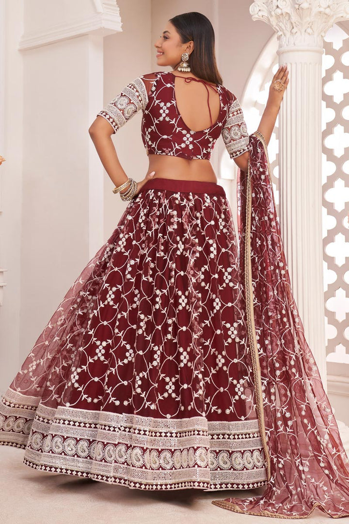 Net Fabric Sangeet Wear Maroon Color Striking Embroidered Lehenga