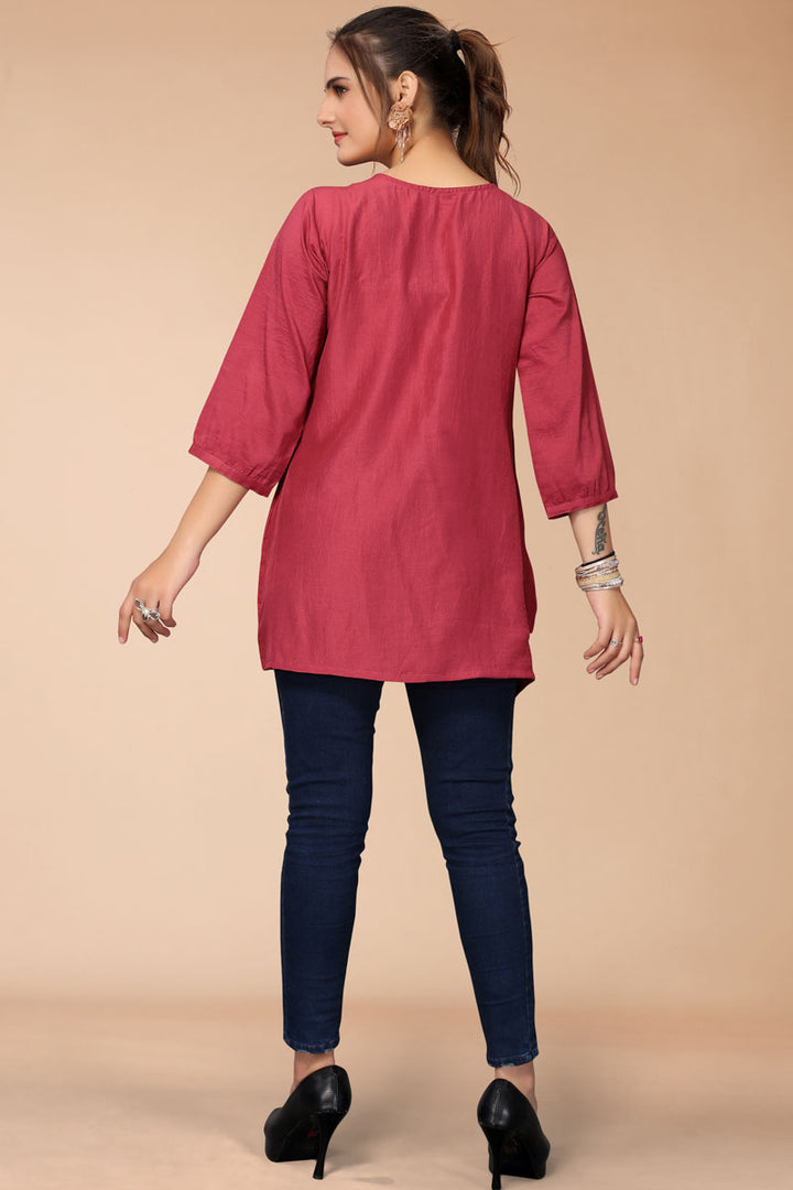Bewitching Embroidered Work On Rani Color Short Kurti In Rayon Fabric
