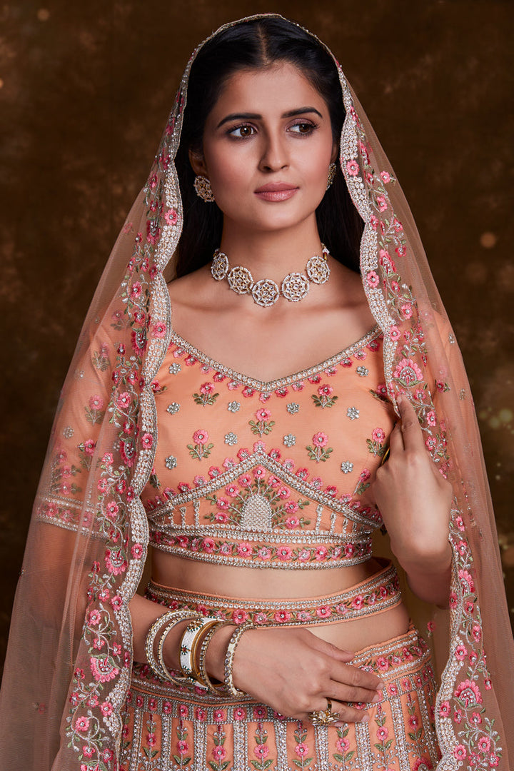 Net Wedding Wear Chaniya Choli In Peach With Embroidery Work And Designer Blouse