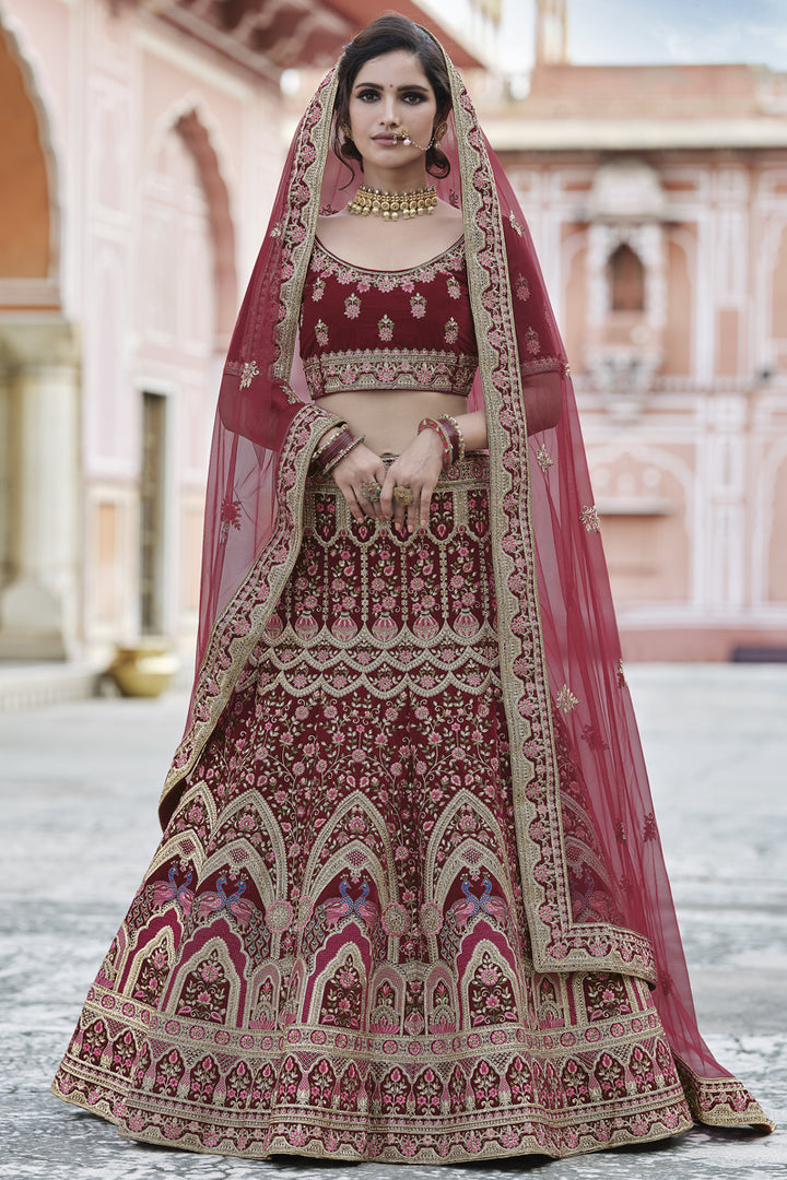 Velvet Heavy Embroidered Wedding Wear Lehenga Choli In Maroon Color
